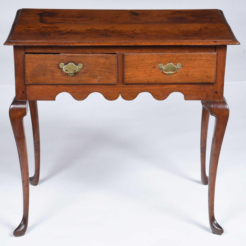 Antique wooden side table with a scalloped apron