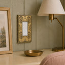 Nouveau Collection brushed gold rocker switch plate in a bedroom