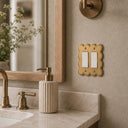 Scallop Collection brushed gold double rocker switch plate in a bathroom