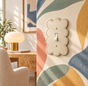 Scalloped Ivory toggle switch plate on a colorful mural wall