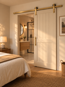 Light Gold barn door hardware on a white plank sliding door between a bedroom and ensuite