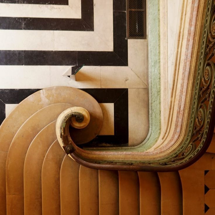 Scrolled handrail over a geometric marble floor