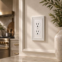 Estate 1-gang duplex outlet cover in White on a light wall in a kitchen beside a marble counter