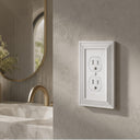 Estate 1-gang duplex outlet cover in White on a light wall in a bathroom with a marble vanity