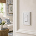 Estate 1-gang rocker switch plate in White on a light wall in a living room with blue floral accents