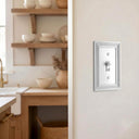 Estate 1-gang toggle switch plate in White on a light wall in a kitchen with open wood shelving