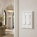Estate 2-gang rocker switch plate in White on a light wall in an entryway with arched windows