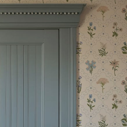 Blue door beside floral wallpaper