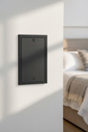 Imperial 1G Blank wall plate in Black on a wall in a styled room