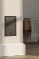 Imperial 1G Blank wall plate in Black on a wall in a styled room