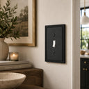 Imperial 1G Toggle wall plate in Black on a wall in a styled room