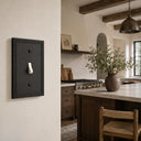 Imperial 1G Toggle wall plate in Black on a wall in a styled room