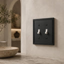Imperial 2G Toggle wall plate in Black on a wall in a styled room