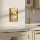 Imperial 1G Duplex wall plate in Brushed Gold on a wall in a styled room