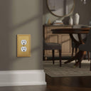 Imperial 1G Duplex wall plate in Brushed Gold on a wall in a styled room