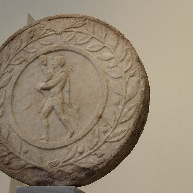 Ancient marble roundel framed by a carved laurel wreath