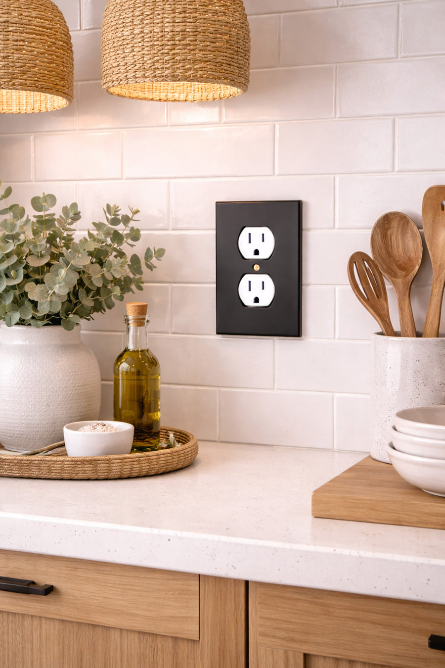 Forge duplex outlet cover in Black on a white subway tile backsplash