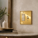 Pearl 2G TR Combo wall plate in Brushed Gold on a wall in a styled room