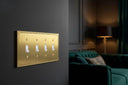 Pearl 4G Toggle wall plate in Brushed Gold on a wall in a styled room