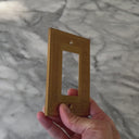 Laurel Brushed Gold wall plate handled close up to show weight and finish