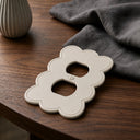 Scallop 1G Duplex Wall Plate in Warm Ivory on a wooden table