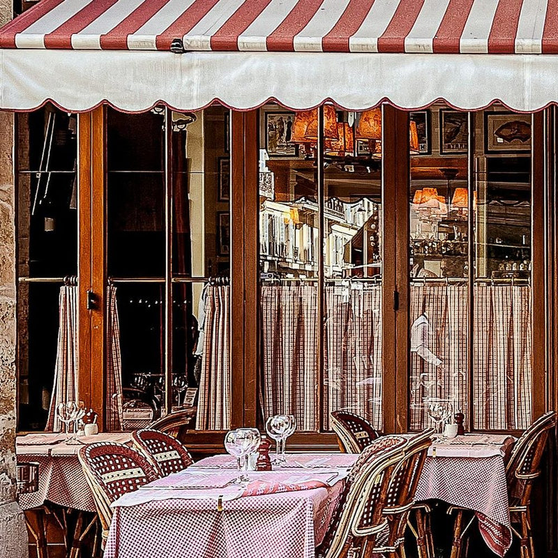 Striped scalloped awning over a Paris cafe terrace