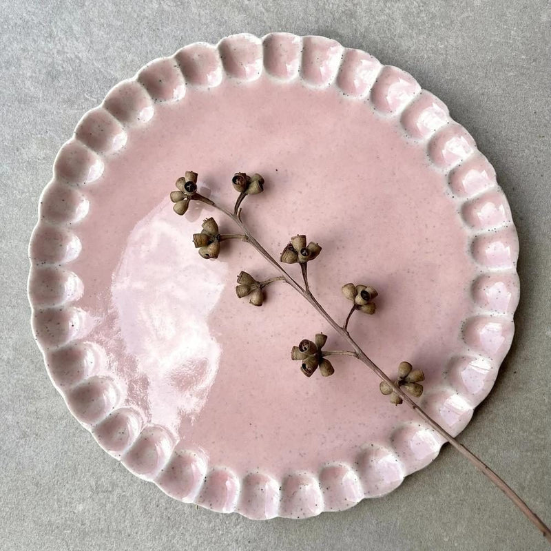 Pink ceramic plate with a scalloped rim