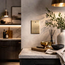 Signature 1G Blank wall plate in Aged Gold on a wall in a styled room