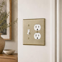 Signature 2G TD Combo wall plate in Aged Gold on a wall in a styled room