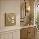 Signature 2G TD Combo wall plate in Aged Gold on a wall in a styled room