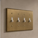 Signature 4-gang toggle switch plate in Aged Gold, room setting