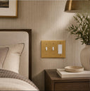 Signature 3G RT Combo wall plate in Brushed Brass on a wall in a styled room